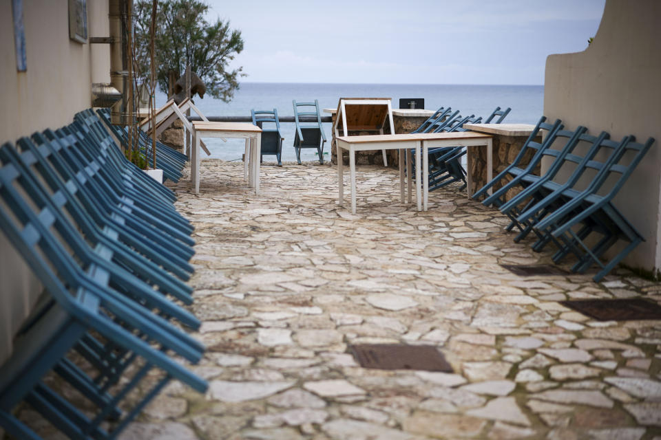 Sillas apoyadas contra la pared en un restaurante sobre la playa de Sperlonga, Italia, que permanece cerrado por el coronavirus el 28 de abril del 2020. (AP Photo/Andrew Medichini)