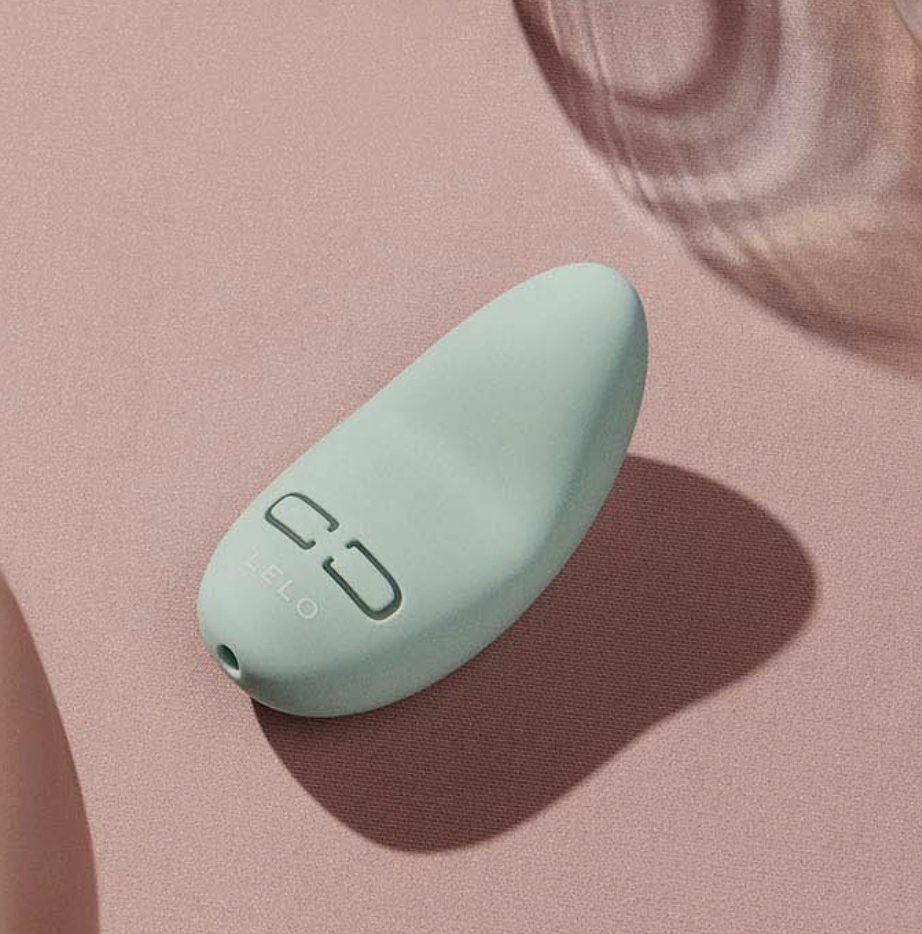 Lily 3 Personal Massager in light mint green blue on pink background (photo via Lelo)