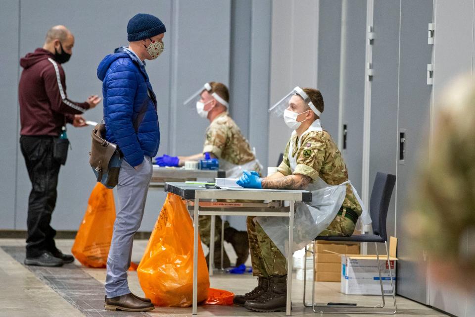 Members of the public are processed by soldiers wearing full PPE (personal protective equipment) at The Exhibition Centre in Liverpool, set up as a mass and rapid testing centre for the novel coronavirus COVID-19, on November 6, 2020. - To avoid extending the lockdown, Johnson is pinning his hopes on an ambitious new programme of Covid testing to detect and isolate infected people, starting with a city-wide trial launching in Liverpool today. (Photo by Peter Byrne / POOL / AFP) (Photo by PETER BYRNE/POOL/AFP via Getty Images)