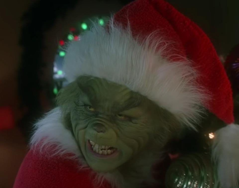 Jim Carrey as the Grinch steals from Cindy Lou Who and her family