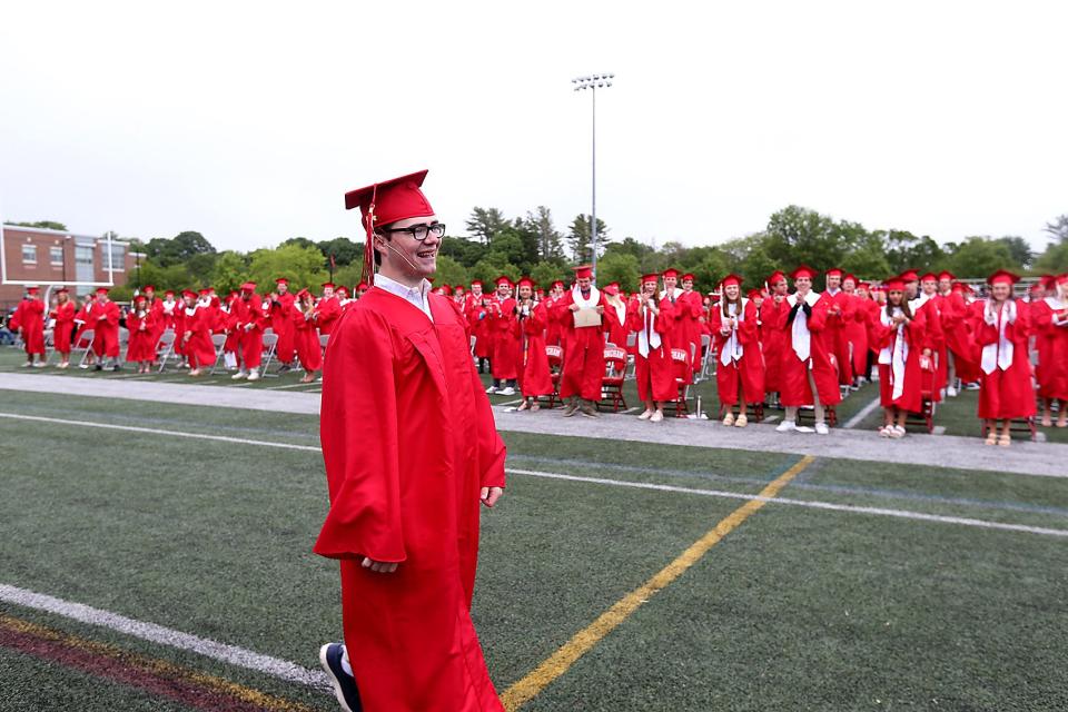 Hingham High Class President Calvin Larson gets a standing ovation from his classmates while walking across the field to receive his diploma during commencement ceremonies for the Class of 2023 on Saturday, June 3, 2023. Hingham High graduated 318 seniors.