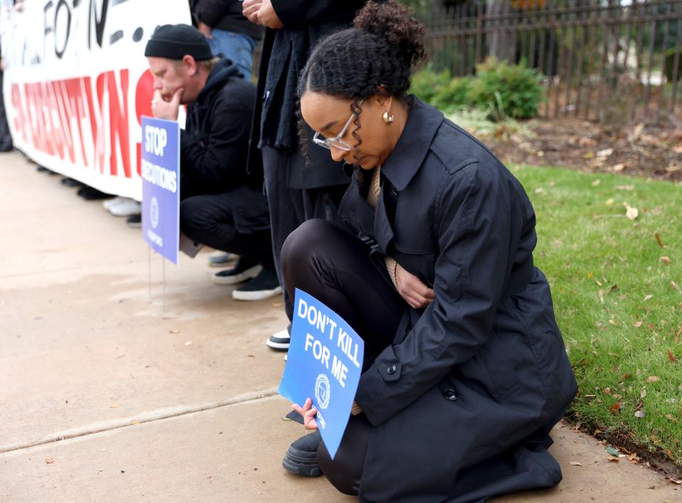 Jasmine Brown-Jutras kneels during a prayer vigil Thursday outside the Governor's Mansion. The vigil was held in protest of the death penalty and the execution of Phillip Dean Hancock.