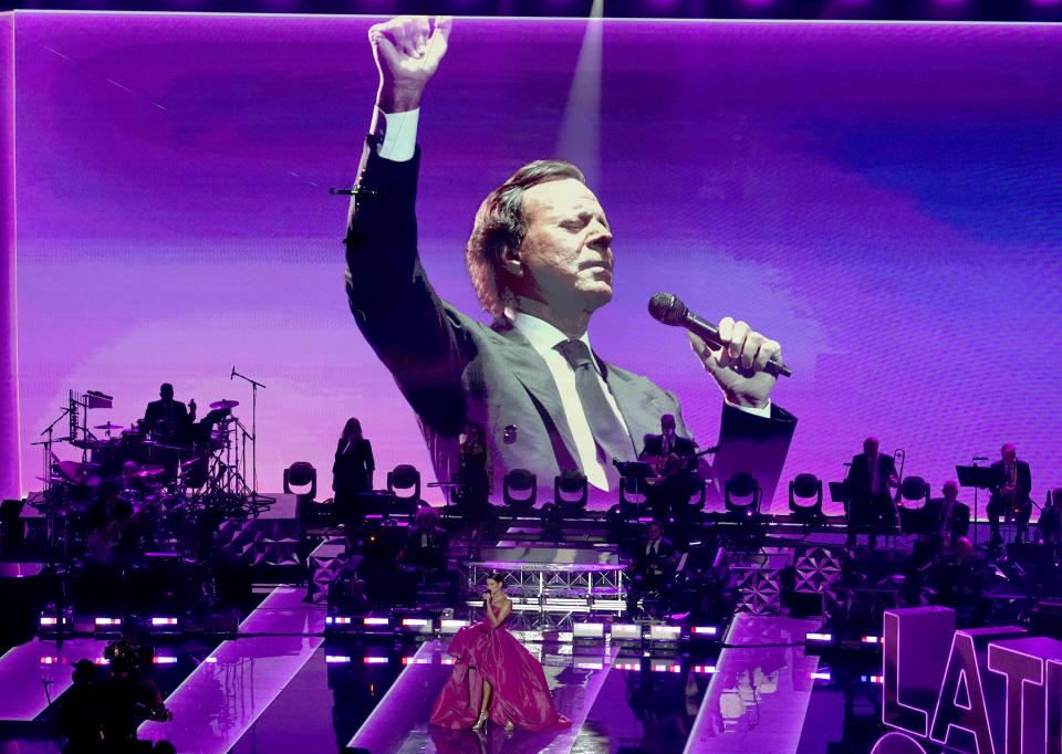 Julio Iglesias is seen on screen as Natalia Jimenez performs during a living legends tribute at the 21st Latin Grammy Awards, airing on Thursday, Nov. 19, 2020, at American Airlines Arena in Miami. (AP Photo/Marta Lavandier)