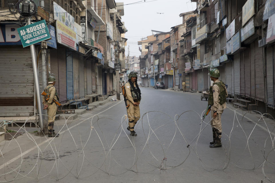 Indian paramilitary force soldiers stand guard near a barbed wire barricade during restrictions in Srinagar Indian controlled Kashmir, Friday, Sept. 27, 2019. Residents in Indian-controlled Kashmir waited anxiously as Indian and Pakistani leaders were scheduled to speak at the U.N. General Assembly later Friday. (AP Photo/ Dar Yasin)