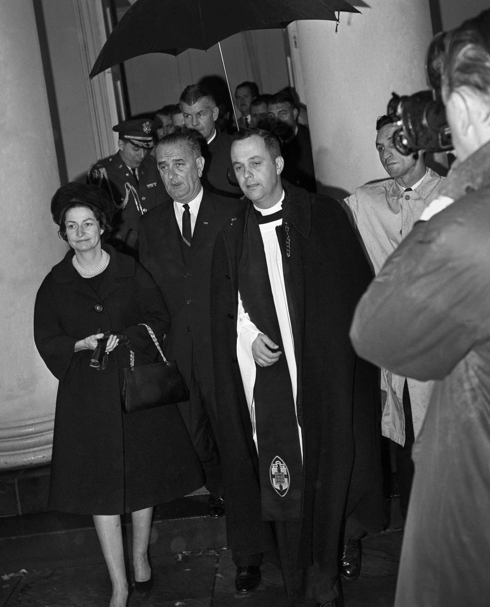 FILE - In this Nov. 23, 1963 file photo, President Lyndon Johnson and his wife, Lady Bird, leave St. John's Episcopal Church in Washington after attending special services. With them is the rector, the Rev. John C. Harper. Johnson was sworn in as president shortly after the assasisnation of John F. Kennedy in Dallas on Nov. 22. (AP Photo)