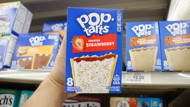 shopper holding up box of pop-tarts at store