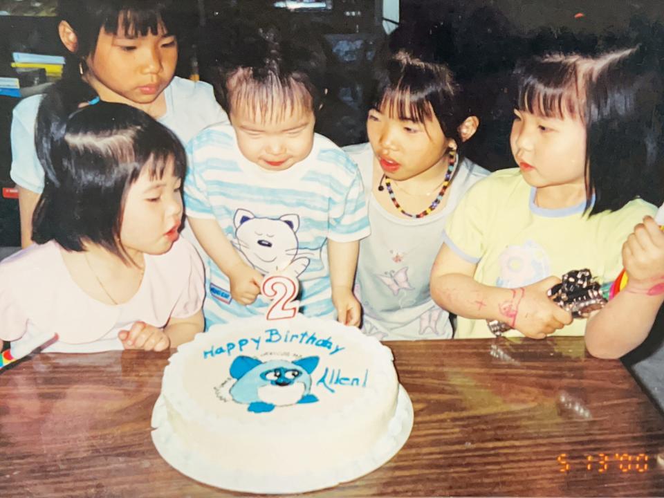 A picture of the siblings as children sat around a birthday cake.