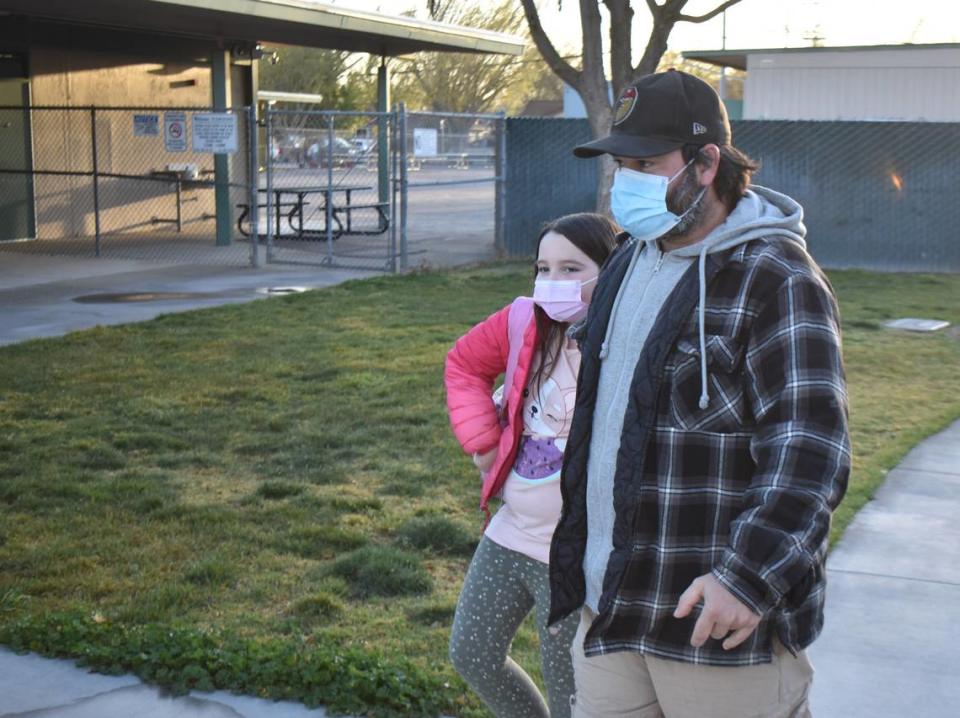 David Jerome walks his daughter, fourth-grader Cloie, onto the Sherwood Elementary School grounds in Modesto on Monday, March 14, 2022. Cloie said she’ll keep her mask on in class for now as a safety measure.