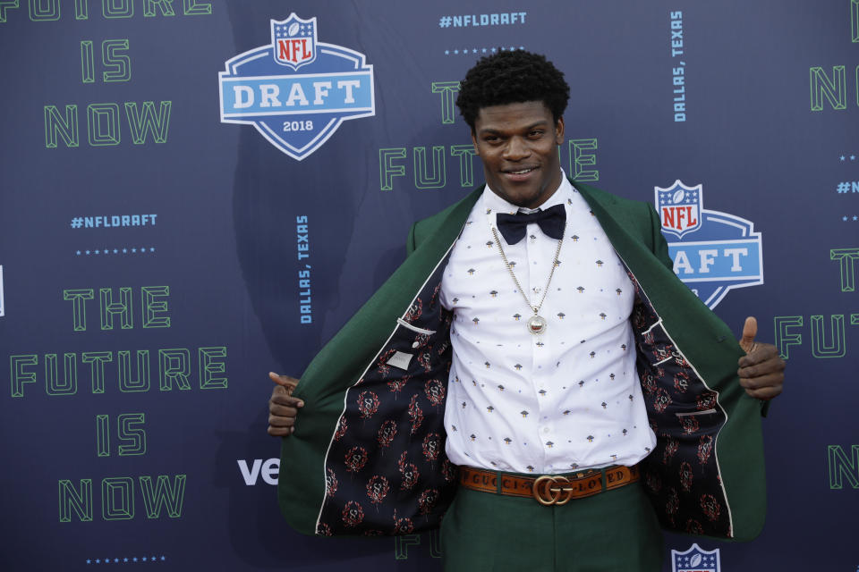 FILE - Louisville's Lamar Jackson poses for photos on the red carpet before the first round of the NFL football draft April 26, 2018, in Arlington, Texas. Jackson complemented the rich green Gucci suit with a white UFO printed shirt by the designer, a signature Gucci belt and went Gucci down to the shoes. (AP Photo/Eric Gay, File)