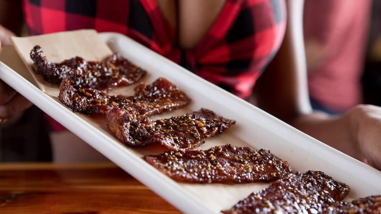 waitress holding plate of bacon