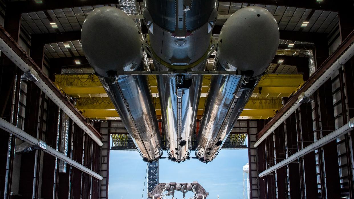  flacon heavy boosters in hangar with open door at the other side 