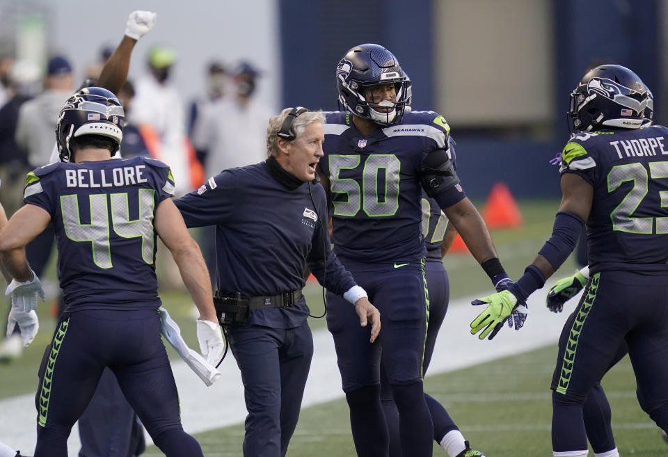 Pete Carroll celebrates with his players, sans mask.