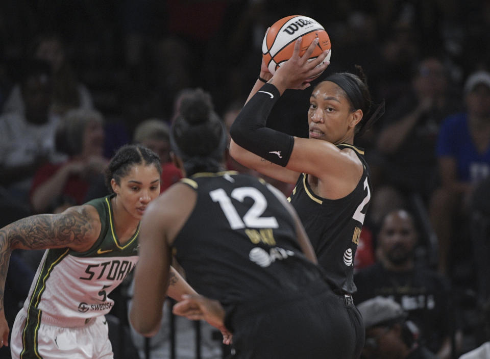 Las Vegas Aces forward A'ja Wilson, right, looks to pass to uard Chelsea Gray (12) to pass during the first half of a WNBA basketball game against the Seattle Storm, Sunday, Aug. 14, 2022, in Las Vegas. (AP Photo/Sam Morris)