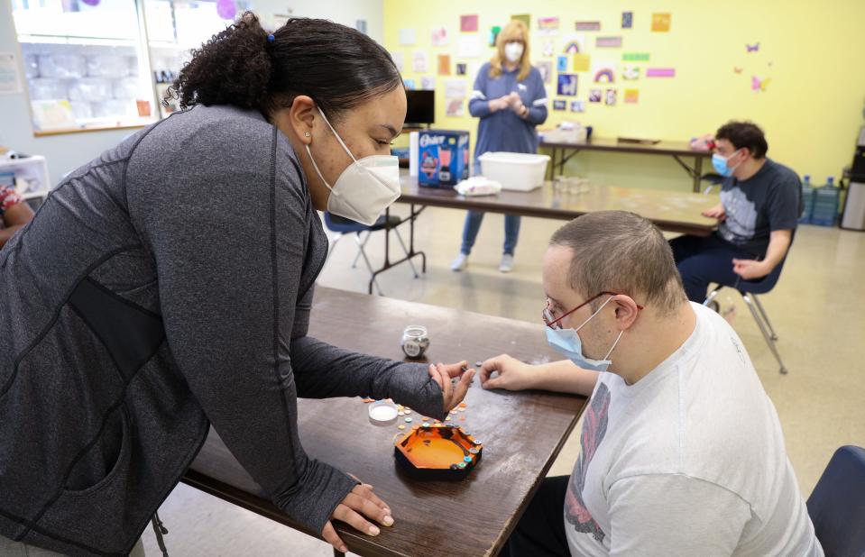 Destiny Roque finds buttons with Robert Alscheff for an art project during the Webster Day Habilitation program run by Heritage Christian Services. Roque works with individuals who attend the program.