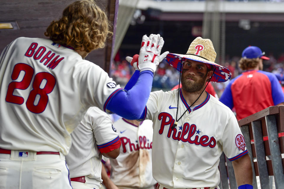 Philadelphia Phillies' Bryce Harper, right, is congratulated in the dugout by Alec Bohm after Harper hit a solo home run off New York Mets starting pitcher Taijuan Walker during the sixth inning of a baseball game, Sunday, Aug. 8, 2021, in Philadelphia. (AP Photo/Derik Hamilton)