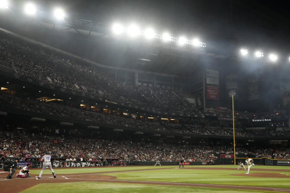Arizona Diamondbacks starting pitcher Zac Gallen, right, throws to Colorado Rockies designated hitter Charlie Blackmon during the first inning of a baseball game Thursday, March 28, 2024, in Phoenix. (AP Photo/Ross D. Franklin)