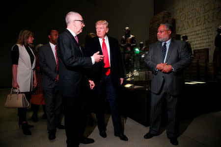 U.S. President Donald Trump (C) views an exhibit on slavery during the American revolution while visiting the National Museum of African American History and Culture in Washington, U.S., February 21, 2017. REUTERS/Jonathan Ernst