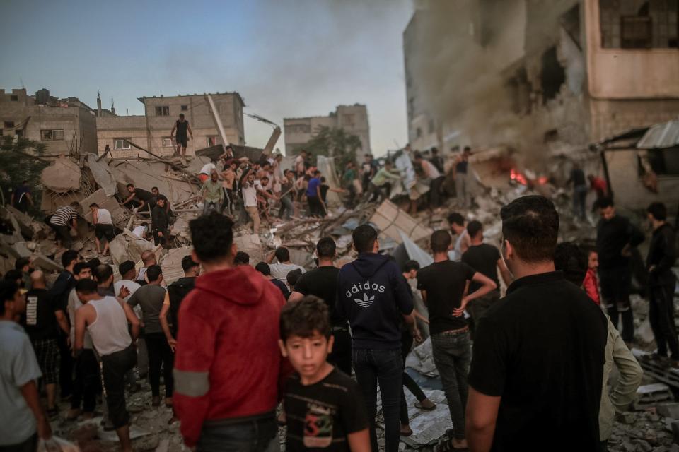 Rescue workers sift through the rubble of buildings destroyed during Israeli air raids in the southern Gaza Strip (Middle East Images/AFP via Getty)