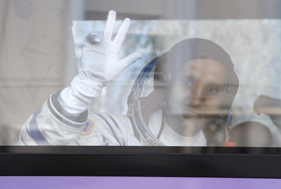 United Arab Emirates astronaut Hazza Almansoori, member of the main crew to the International Space Station (ISS), waves to his relatives from a bus prior the launch of Soyuz-FG rocket at the Russian leased Baikonur cosmodrome, Kazakhstan, Wednesday, Sept. 25, 2019. (AP Photo/Dmitri Lovetsky. Pool)