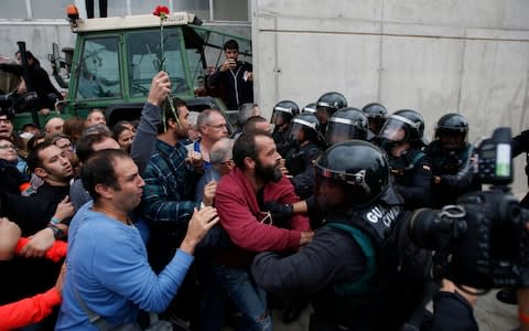 Civil guards clear people away from the entrance of a sports center, assigned to be a referendum polling station by the Catalan government in Sant Julia de Ramis, near Girona, Spain, Sunday, Oct. 1, 2017 - Credit: AP