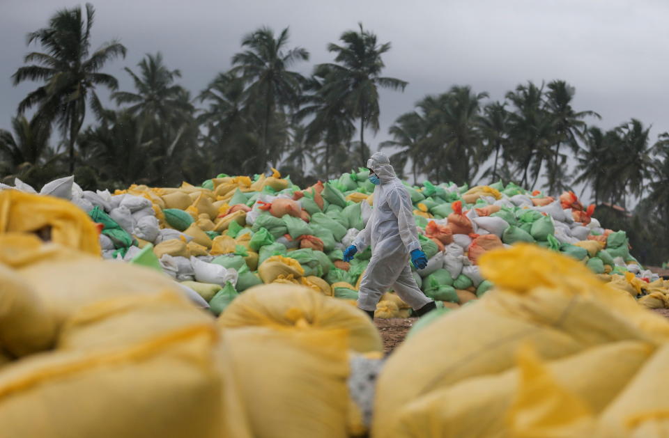 A Sri Lankan navy member walks past the sacks of collected debris washed to a beach from the MV X-Press Pearl container ship which caught fire and sunk off the Colombo Harbour, in Ja-Ela, Sri Lanka June 14, 2021. REUTERS/Dinuka Liyanawatte     TPX IMAGES OF THE DAY