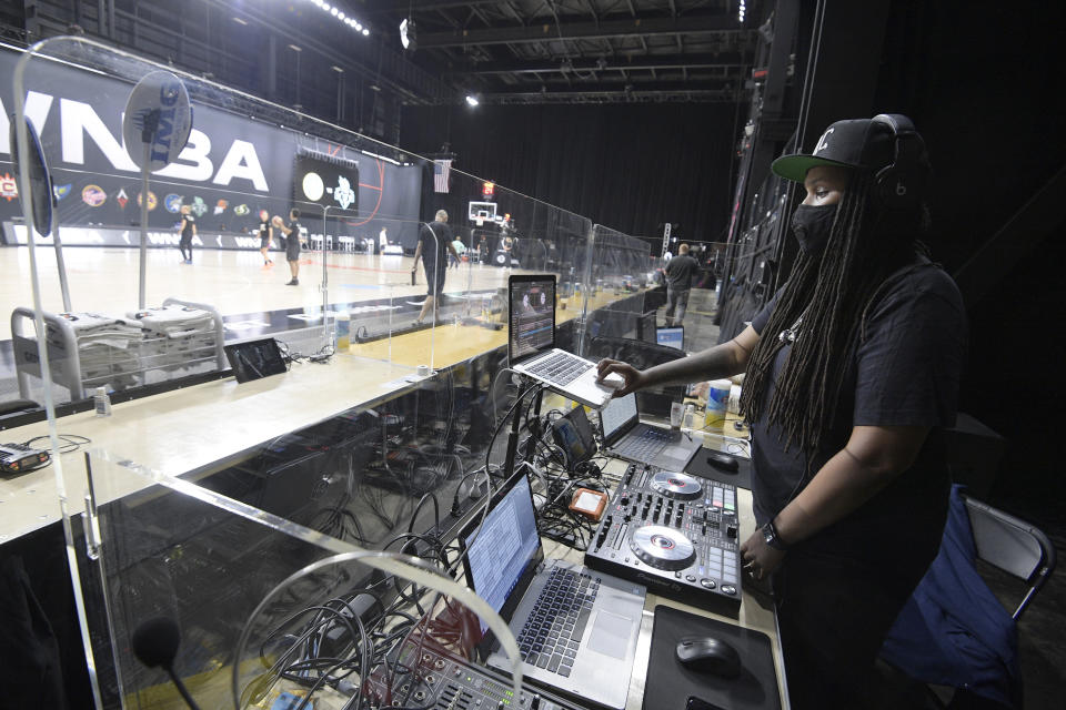 Nicole Mosley, who goes by her stage name DJ Heat, performs music behind glass partitions during warmups before a WNBA basketball game between the Chicago Sky and the New York Liberty, Tuesday, Aug. 25, 2020, in Bradenton, Fla. Performing in the WNBA bubble at games presents a new experience for DJs and announcers since there are only a handful of people in attendance at games besides the players. (AP Photo/Phelan M. Ebenhack)