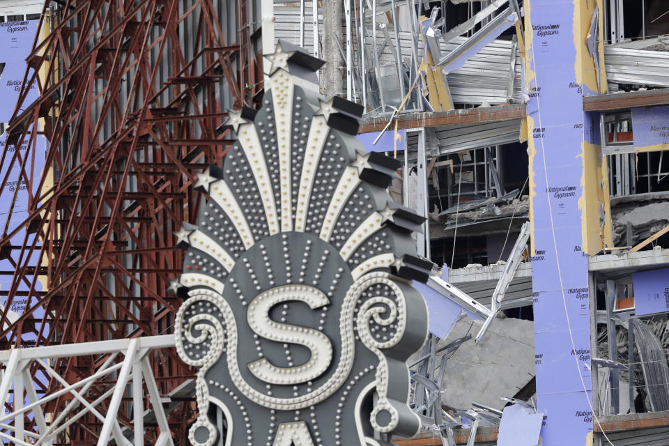 The Saenger Theater sign is seen in the foreground of the damaged Hard Rock Hotel, Thursday, Oct. 17, 2019, in New Orleans. The 18-story hotel project that was under construction collapsed last Saturday, killing three workers. Two bodies remain in the wreckage. (AP Photo/Gerald Herbert)