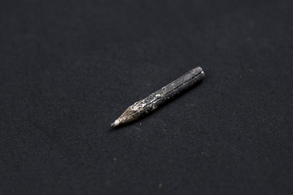 In this Thursday, March 26, 2019 photo, a wooden pencil found inside the clothes of a victim's body is seen photographed after being exhumed from a mass grave at the cemetery of Paterna, near Valencia, Spain, as archaeologists conduct forensic analysis of the remains. DNA tests will be conducted in the hope of confirming the identities of those who disappeared eight decades ago, believed to have been executed by the forces of Gen. Francisco Franco during and after the 1936-39 Spanish Civil War. (AP Photo/Emilio Morenatti)