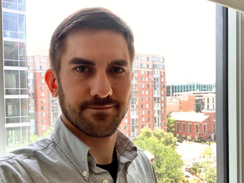 A headshot of a man in front of a window.