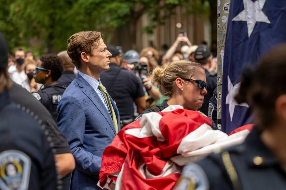 Interim Chancellor Lee Roberts and police officers work to rehang an American flag after it was brought down by demonstrators and replaced with a Palestinian flag Tuesday, April 30, 2024 at UNC-Chapel Hill.