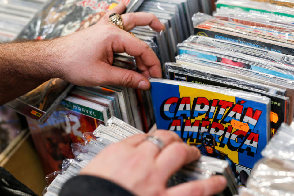 close up of someone sorting through a pile of comics