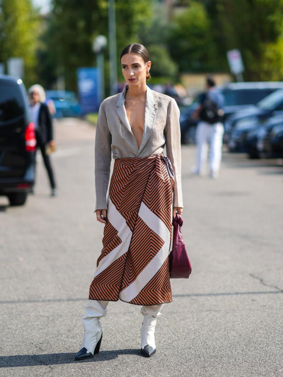 A Fashion Week guest dons monochrome cowboy boots with a chevron wrap skirt 