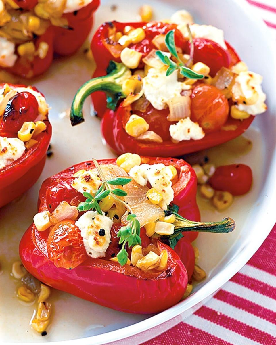 baked bell beppers stuffed with summer vegetables and cheese on a platter