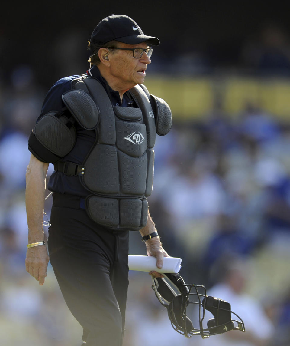 TV host Larry King works as the home plate umpire during the Old-Timers game prior to a baseball game between the Atlanta Braves and the Los Angeles Dodgers Saturday, June 8, 2013, in Los Angeles. King, the suspenders-sporting everyman whose broadcast interviews with world leaders, movie stars and ordinary Joes helped define American conversation for a half-century, died Saturday, Jan. 23, 2021, at age 87. (Keith Birmingham/The Orange County Register/SCNG via AP)