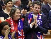 Members of the European Parliament react after voting on the Brexit deal during a plenary session at the European Parliament in Brussels