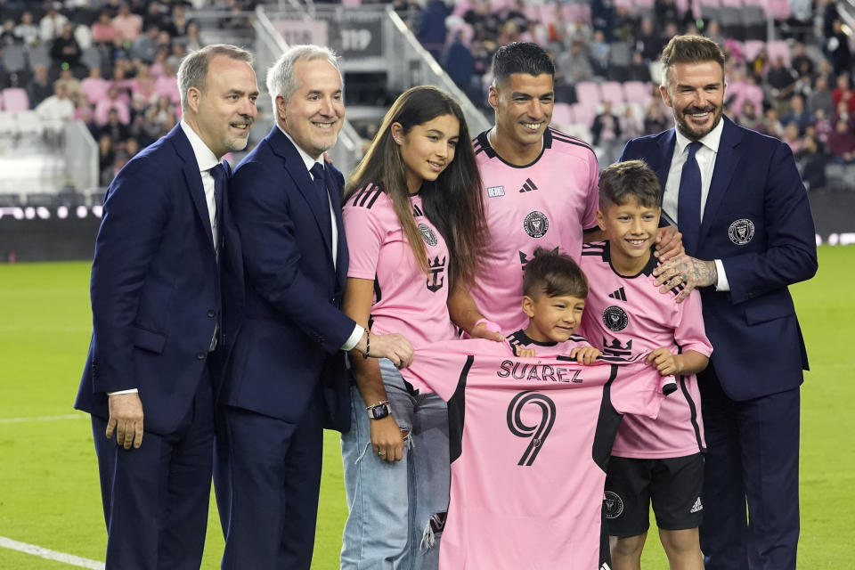 Inter Miami co-owner David Beckham, right, poses with Inter Miami forward Luis Suarez, second from right at rear, and his family before the team's MLS soccer match against Real Salt Lake, Wednesday, Feb. 21, 2024, in Fort Lauderdale, Fla. At left is Inter Miami co-owner Jose Mas, and second from left is manager owner Jorge Mas. (AP Photo/Lynne Sladky)