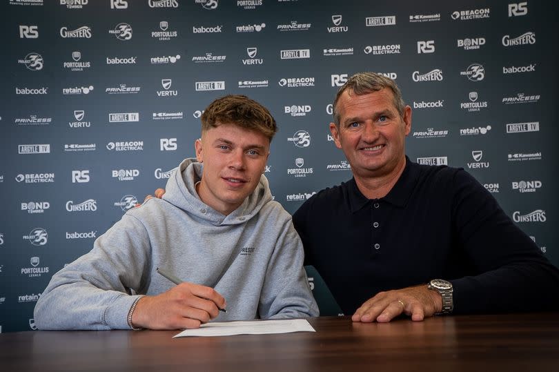 Argyle first-year professional Josh Bernard signs his contract watched by first team coach Kevin Nancekivell