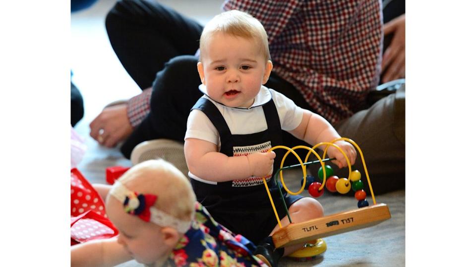 A baby Prince George playing with toys