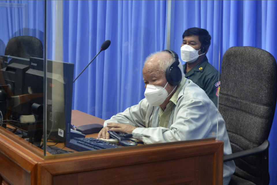 In this photo released by the Extraordinary Chambers in the Courts of Cambodia, Khieu Samphan, foreground, former Khmer Rouge head of state, sits in a courtroom during a hearing at the U.N.-backed war crimes tribunal in Phnom Penh, Cambodia, Monday, Aug. 16, 2021. Khieu Samphan, the last living leader from the inner circle of Cambodia's brutal Khmer Rouge regime, is to appear in court Monday as he seeks to overturn his conviction on genocide charges before a long-running international tribunal. (Nhet Sok Heng/Extraordinary Chambers in the Courts of Cambodia via AP)
