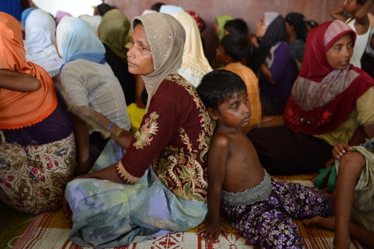 Rohingya women and children from Myanmar sit at a new confinement area in Bayeun, Aceh province on May 21, 2015 after being rescued