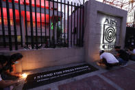 Employees light candles outside the headquarters of broadcast network ABS-CBN corp. on Tuesday, May 5, 2020 in Quezon city, Metro Manila, Philippines. A Philippine government agency has ordered the country's leading broadcast network, which the president has targeted for it's critical news coverage, to halt operations after its congressional franchise expired, sparking shock over the loss of a major news provider during the coronavirus pandemic. (AP Photo/Aaron Favila)