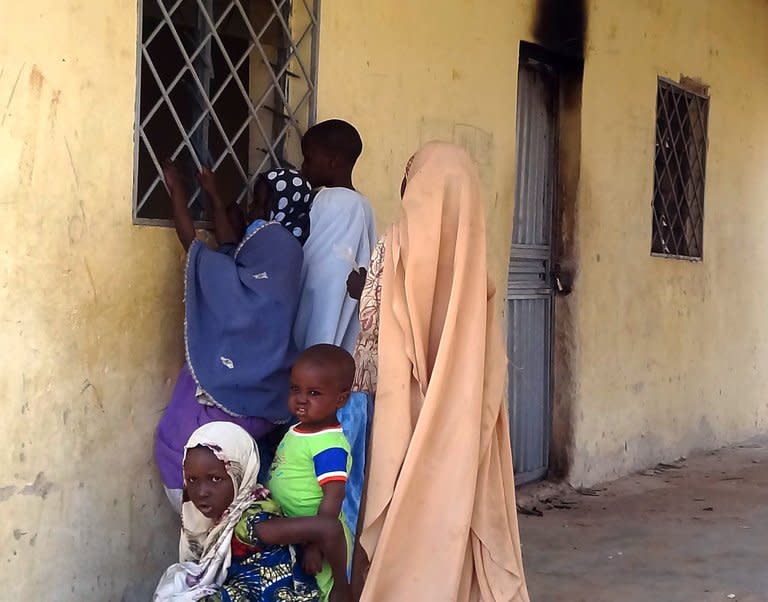 Children peep through the iron bars of a polio clinic on February 8, 2013 in the northern Nigerian city of Kano. It was one of two clinics targeted by gunmen