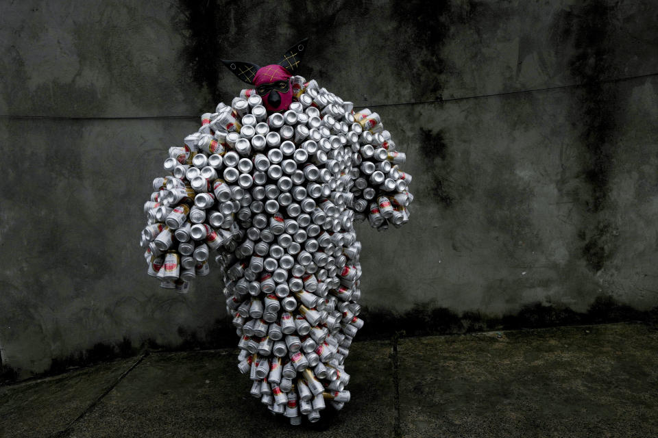 A reveler wearing a costume made from recycled aluminum cans, parades in the 'bloco da latinha' Carnival street party, in Madre de Deus, Brazil, Sunday, Feb. 11, 2024. Each costume — called a “pierro” — is made from approximately 1,600 cans gathered over the course of the previous months, then thoroughly washed to dispose of lingering odors. (AP Photo/Eraldo Peres)