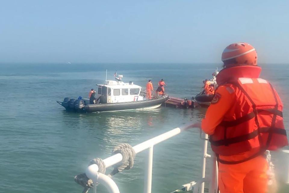Taiwanese coast guards inspect a vessel that capsized during a chase off the coast of Kinmen archipelago in Taiwan, Wednesda (AP)