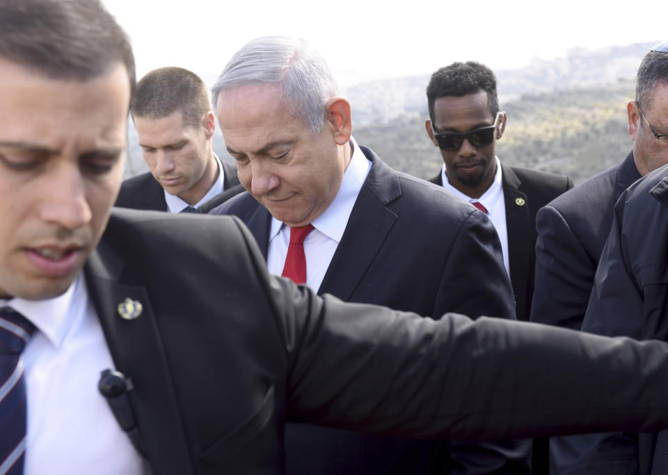 Israeli Prime Minister Benjamin Netanyahu, center, surrounded by bodyguards, walks to get an overview of the West Bank Israeli settlement of Har Homa where he announced a new neighborhood is to be built, Thursday, Feb. 20, 2020. (Debbie Hill/Pool via AP)