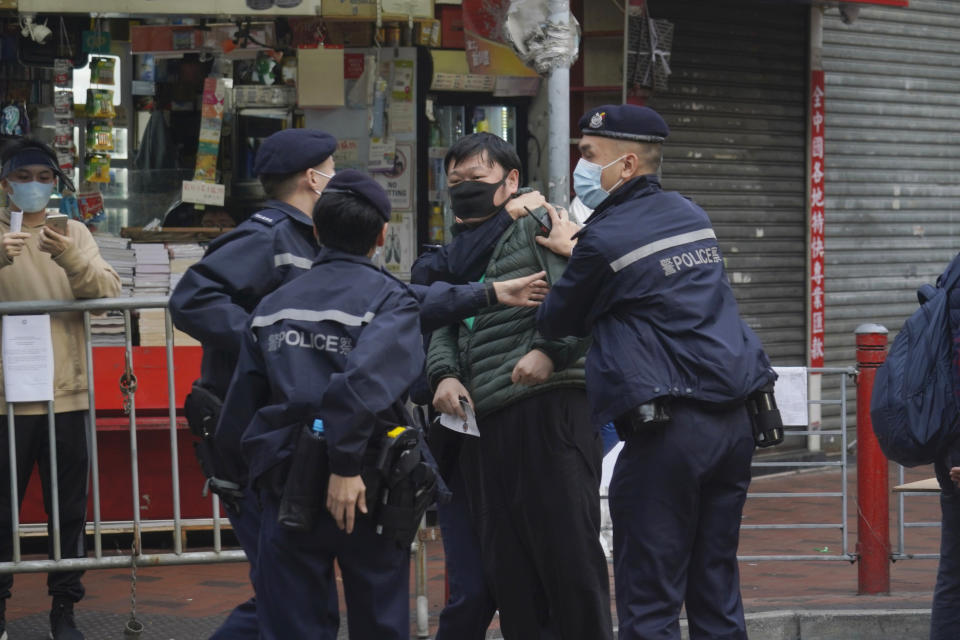 A man is detained after confronting a police officer as he wants to enter the closed area in Jordan area of Hong Kong, Saturday, Jan. 23, 2021. Thousands of Hong Kong residents were locked down Saturday in an unprecedented move to contain a worsening outbreak in the city, authorities said. (AP Photo/Kin Cheung)