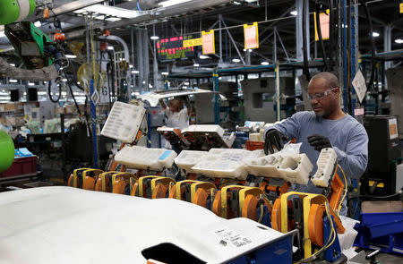 A General Motors assembly worker loads the HIC plastic caps at a Collaborative Robot station, intended for 2018 Chevrolet Bolt EV and 2018 Sonic vehicles, at Orion Assembly in Lake Orion, Michigan, U.S., March 19, 2018. REUTERS/Rebecca Cook/Files