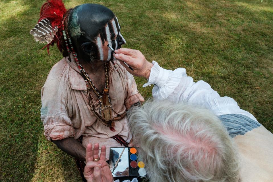 Bob Cairns, organizer of the annual Revolutionary War reenactments at Fort Laurens, in Lawrence Township, paints Dave Graham, who was portraying a Lenni Lenape Native American Indian, Saturday, during the annual event.
