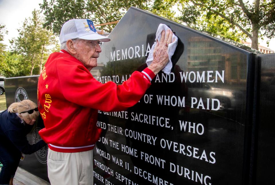 (5/28/22)96-year-old WWII veteran former Marine corporal Frank Wright helps to clean the WWII memorial in downtown Stockton. The Stockton Rotary Club organized the clean up on Saturday, May 28, 2022. The club erected the black marble memorial in 2002. Wright's bright red jacket draws attention to him. 
