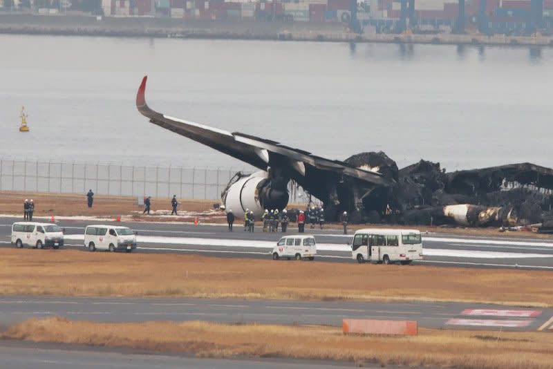 Officials investigate a burnt Japan Airlines Airbus A350 plane Wednesday after a fiery collision the day before with a Japan Coast Guard aircraft at Haneda Airport in Tokyo. Photo by Keizo Mori/UPI